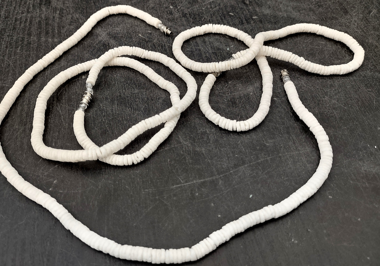 White Puka-Style Shell Necklace - (1 necklace 18 inches x 4-5mm) on blue background. Copyright 2022 SeaShellSupply.com.