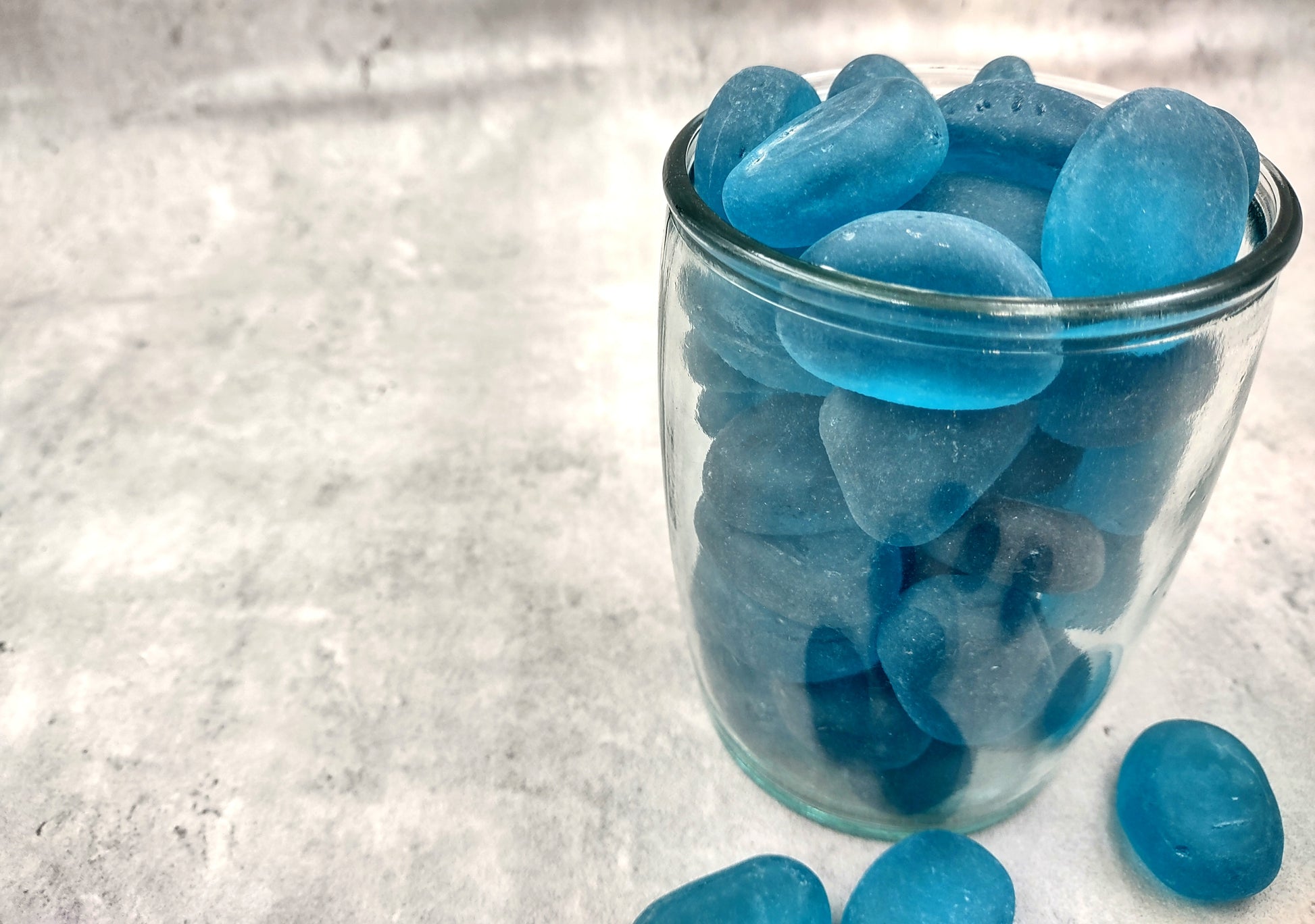 Beach Glass - Rounded Aqua Blue Pebbles - (approx. 1 Kilogram/2.2 lbs. 1-1.5 inches). Multiple smooth blue glass pebbles in a pile. Copyright 2024 SeaShellSupply.com.