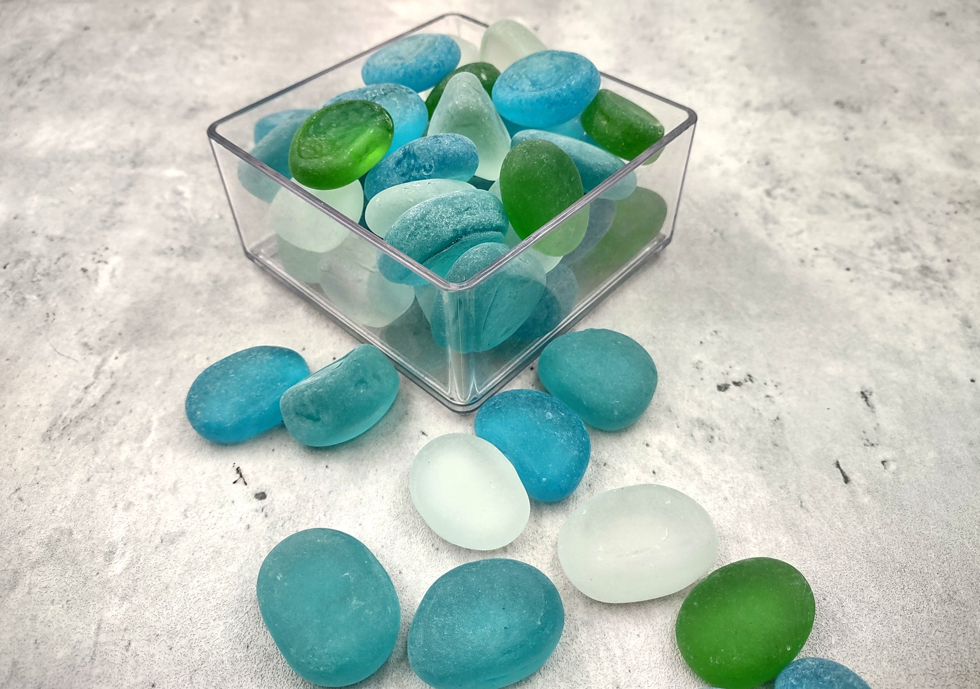 Beach Glass - Rounded Blue, Green & White Assorted Pebbles - (approx. 1 Kilogram/2.2 lbs. 1-1.5 inches). Multiple colored pebbles in a pile. Copyright 2024 SeaShellSupply.com.