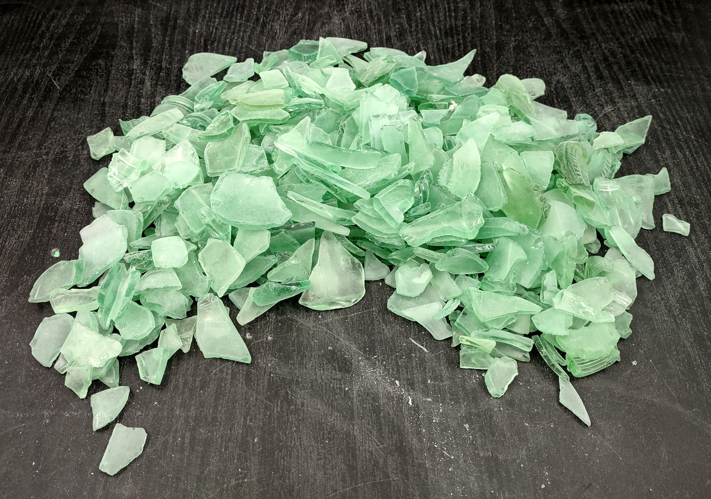 Beach Glass - Medium Tumbled Rough Coke Bottle Green - (approx. 1 Kilogram/2.2 lbs. .5-1.25 inches). Multiple green glass pieces in different shapes. Copyright 2024 SeaShellSupply.com.