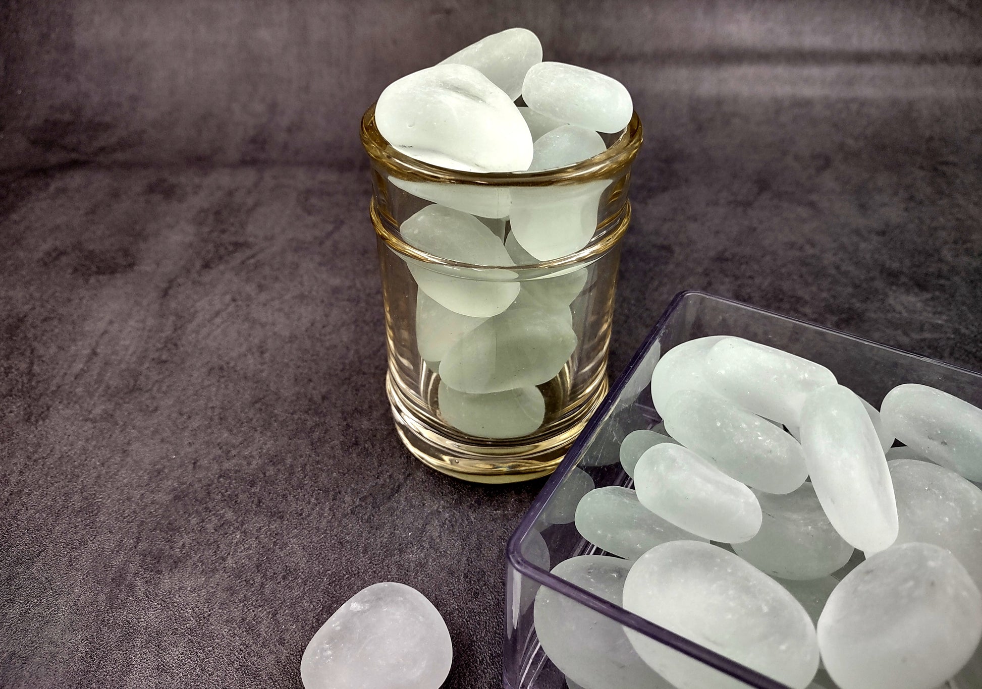 Beach Glass - Rounded Clear-White Frosted Pebbles - (approx. 1 Kilogram/2.2 lbs. 1-1.5 inches). Multiple lightly colored shells in a pile. Copyright 2024 SeaShellSupply.com.