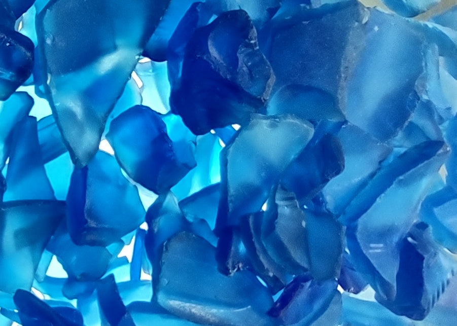 Beach Glass - Medium Tumbled Rough Cobalt Blue - (approx. 1 Kilogram/2.2 lbs. .5-1.25 inches). Multiple shaded blue tiles in a pile, all are different sizes and shapes. Copyright 2024 SeaShellSupply.com.