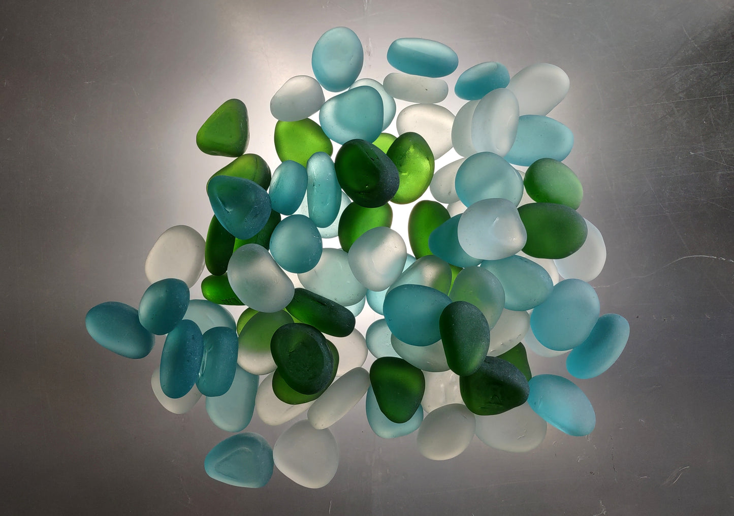 Beach Glass - Rounded Blue, Green & White Assorted Pebbles - (approx. 1 Kilogram/2.2 lbs. 1-1.5 inches). Multiple colored pebbles in a pile. Copyright 2024 SeaShellSupply.com.