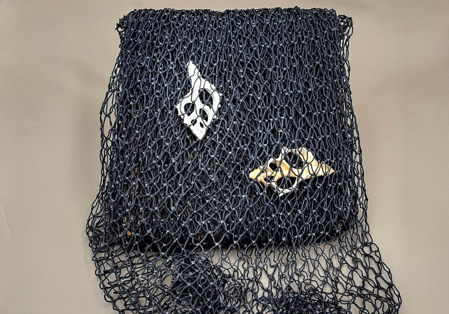Fishing Net - Used (4 X 9 feet). One black tied fishing net that comes folded and banded. Copyright 2022 SeaShellSupply.com.