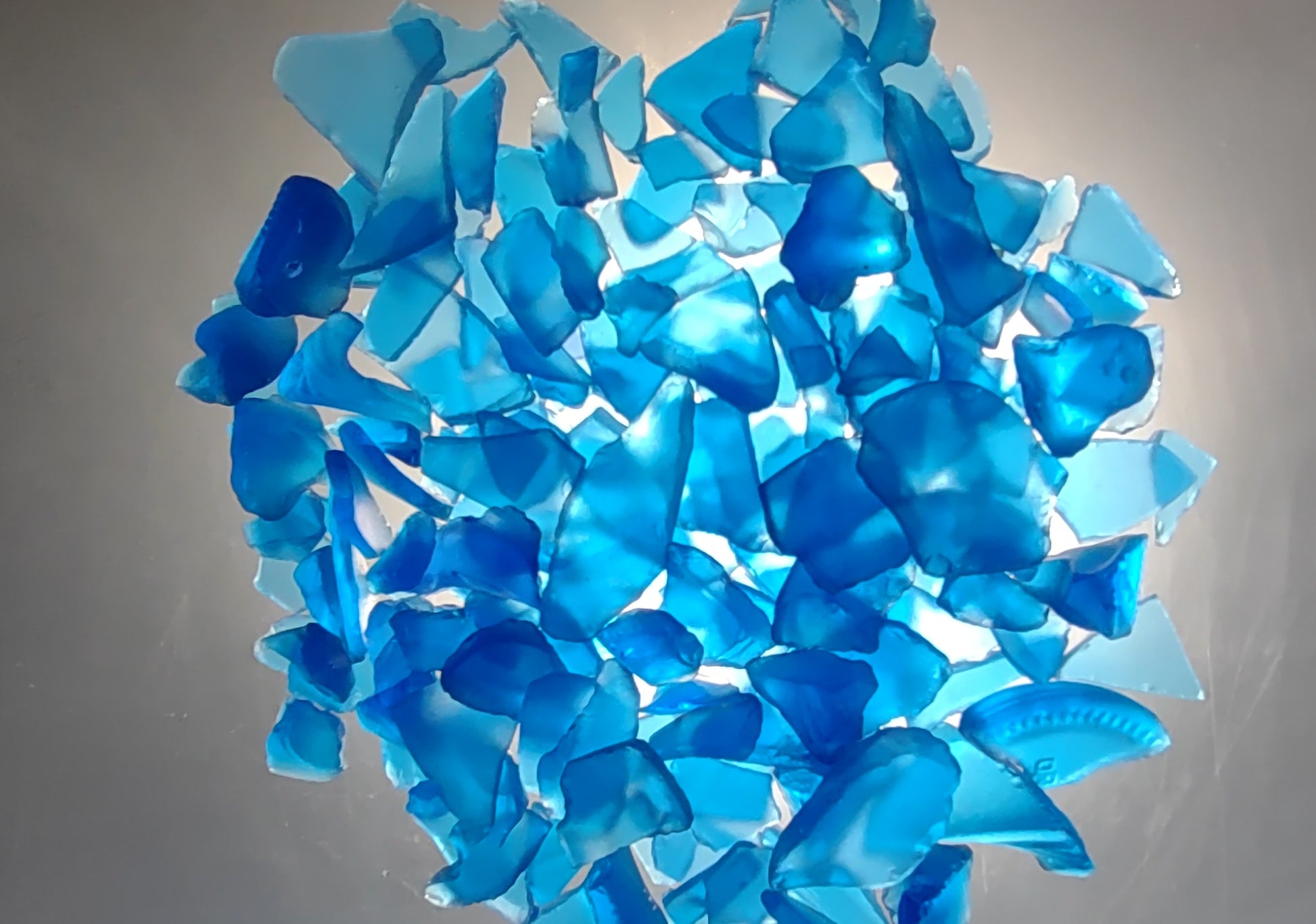 Beach Glass - Medium Tumbled Rough Cobalt Blue - (approx. 1 Kilogram/2.2 lbs. .5-1.25 inches). Multiple shaded blue tiles in a pile, all are different sizes and shapes. Copyright 2024 SeaShellSupply.com.