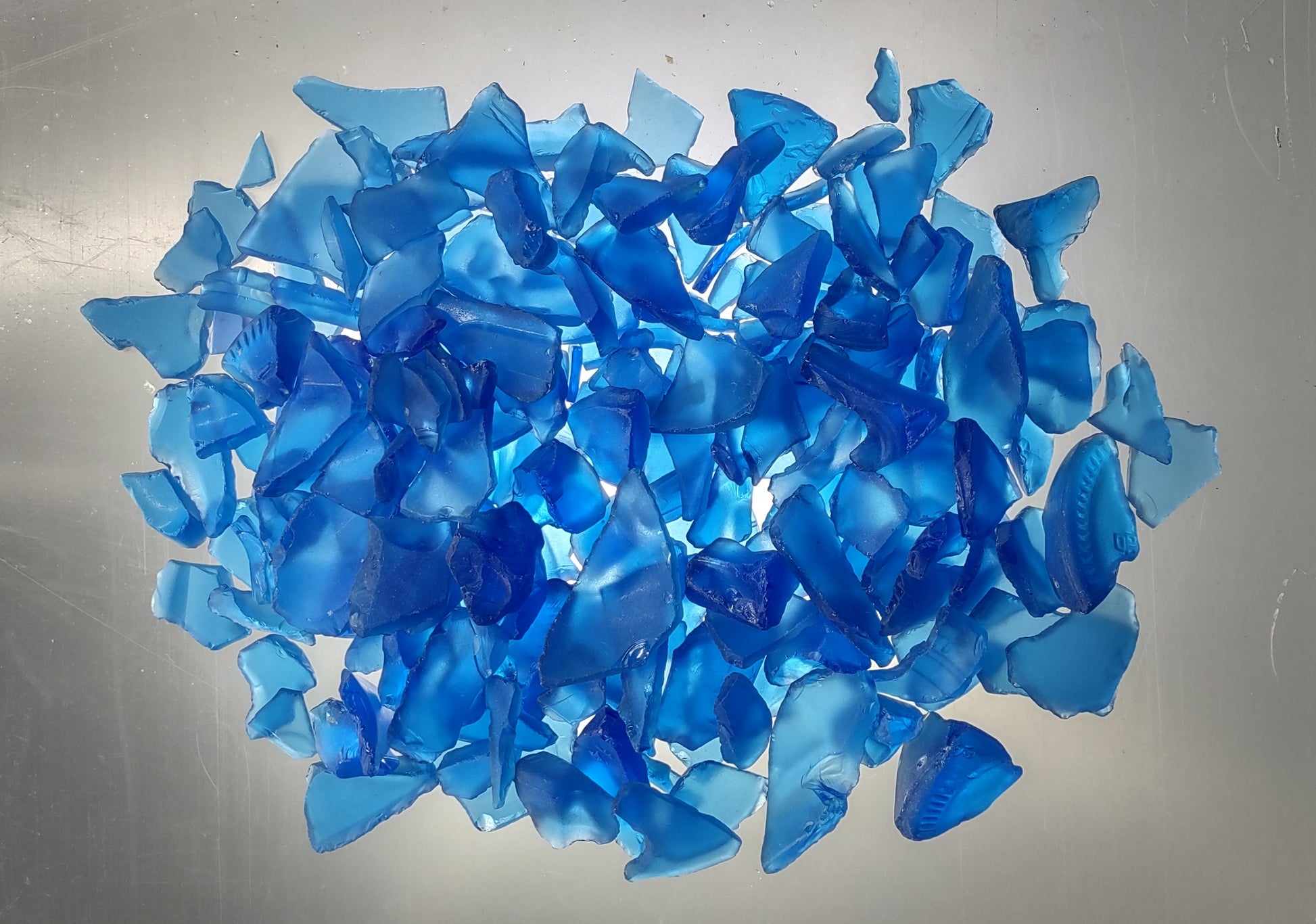 Beach Glass - Medium Tumbled Rough Cobalt Blue - (approx. 1 Kilogram/2.2 lbs. .5-1.25 inches). Multiple shaded blue tiles in a pile, all are different sizes and shapes. Copyright 2024 SeaShellSupply.com.
