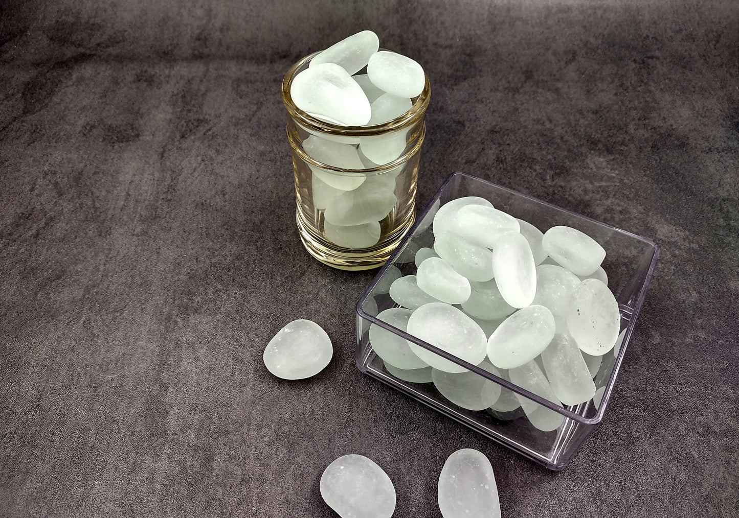 Beach Glass - Rounded Clear-White Frosted Pebbles - (approx. 1 Kilogram/2.2 lbs. 1-1.5 inches). Multiple lightly colored shells in a pile. Copyright 2024 SeaShellSupply.com.